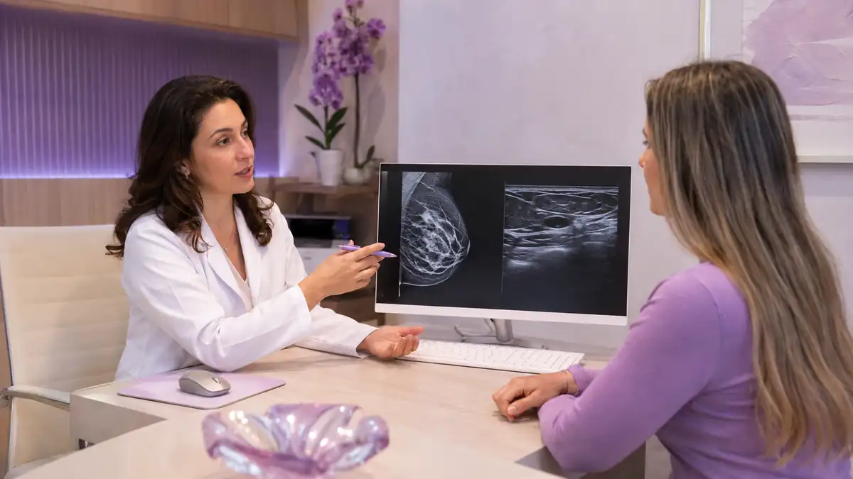 Médica compara mamografia e ultrassonografia na tela, durante a consulta